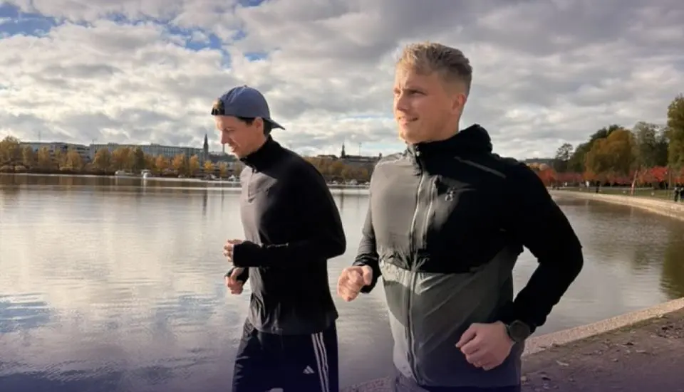 Two members of the Brella team running along the water